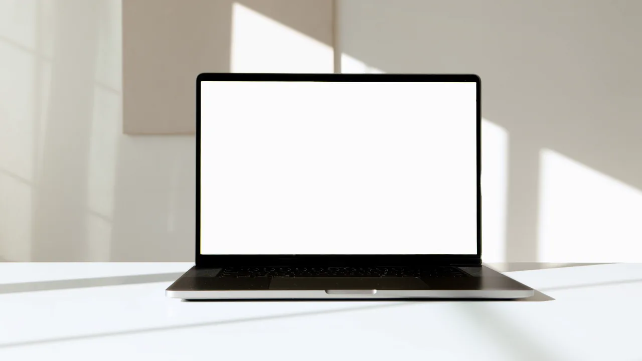 A laptop on a white table in a sunlit room, showing a local garden business's new website as it is built